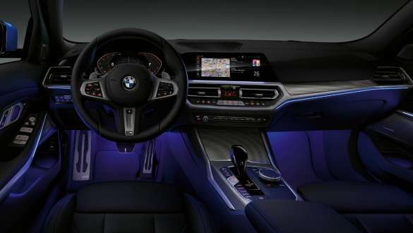 BMW 3シリーズ セダン、アンビエント・ライト。G20 ブルーのアンビエント・ライトがレッグ・ルームを照らす BMW 3シリーズ セダンのコックピット。 G20