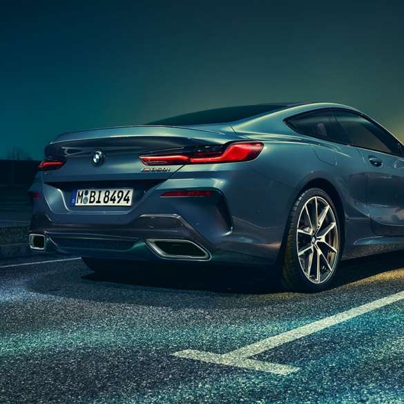 BMW 8シリーズ クーペ、斜めからのリヤ・ビュー。 BMW 8シリーズ クーペ、斜めからのリヤ・ビュー、夜景を背景に。
