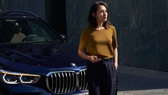 BMW前に女性 BMWロードサイド・アシスタンス 女性がBMWの前に