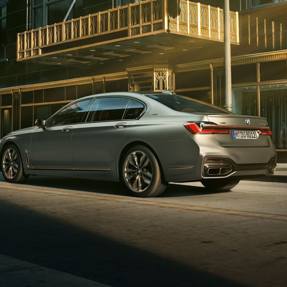 V12エンジン搭載のBMW M760Li xDrive BMW M760Li xDrive 、都会の超高層ビルを背景にした斜め後方からの写真