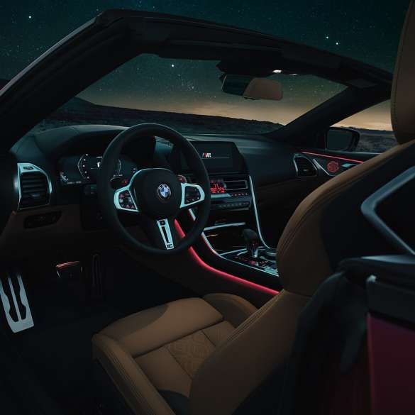 BMW M8 Competition カブリオレ、コックピット F91 BMW M8 Competition カブリオレ、M レザー・ステアリング・ハンドルと赤のアンビエントライトを備えた夜間のコックピット。F91