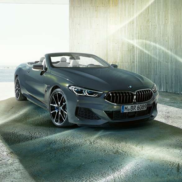 BMW M850i xDrive カブリオレ、スリークォータービュー。G14 BMW M850i xDrive カブリオレ (ソフトトップを開けた状態)、海岸を背景にしたスリークォータービュー。G14