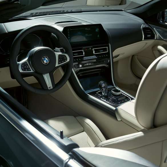BMW M850i xDrive カブリオレ、コックピット。G14 BMW M850i xDrive カブリオレのドラバイト・グレー・メタリックカラー (ソフトトップを開けた状態)、M レザーステアリング・ハンドルを備えたコックピット。G14
