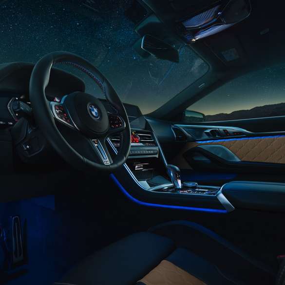 BMW M8 コンペティションクーペ、コックピット。F92 BMW M8 コンペティションクーペ、Mレザーステアリングホイールとブルーの間接照明が美しい夜のコックピット。F92