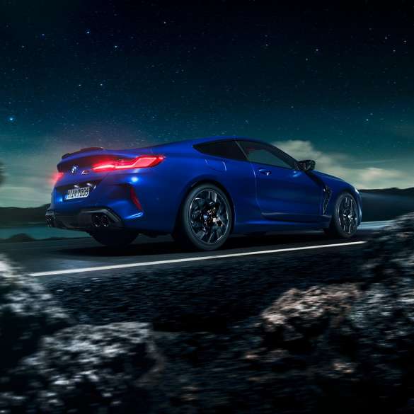 BMW M8 コンペティションクーペ、スリークォーターサイドビュー。F92 BMW M8 コンペティションクーペ(塗色マリーナベイ ブルーメタリック)。満天の星を背景に疾走するスリークォーターサイドビュー。F92