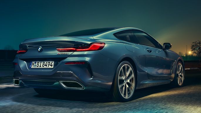 BMW M850i xDriveクーペ、リアビュー。G15 BMW M850i xDriveクーペ(塗色バルセロナ ブルーメタリック)。夜間に疾走するリアビュー。G15