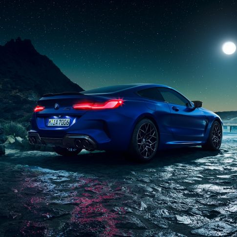 BMW M8 コンペティションクーペ、スリークォーターリアビュー。F92 BMW M8 コンペティションクーペ(塗色マリーナベイ ブルーメタリック)。満月を背景にきらめくLEDテールランプが印象的なスリークォーターリアビュー。F92