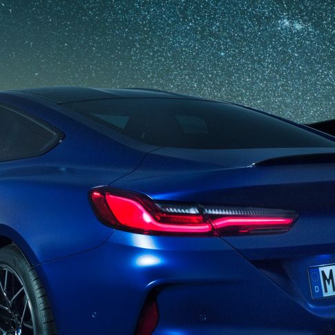 Mリアスポイラー F92 BMW M8 コンペティションクーペ(塗色マリーナベイ ブルーメタリック)。夜間におけるショルダー部のクロースアップビュー。カーボンのMリアスポイラーが見える。F92