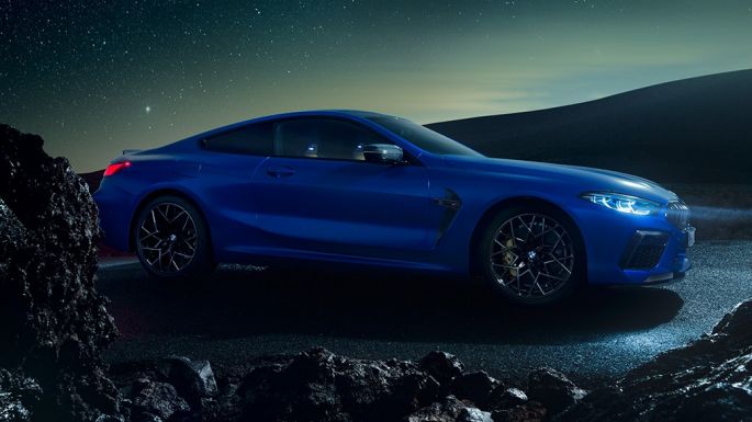 BMW M8 コンペティションクーペ、スリークォーターサイドビュー。F92 BMW M8 コンペティションクーペ(塗色マリーナベイ ブルーメタリック)。夜間に停車中のスリークォーターサイドビュー。F92