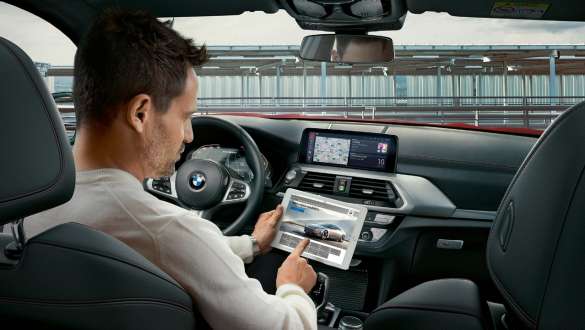 BMW コネクテッド。F98 BMW X4 M オートモビル、BMW コネクテッド、照らされた地球儀を持った女性。F98