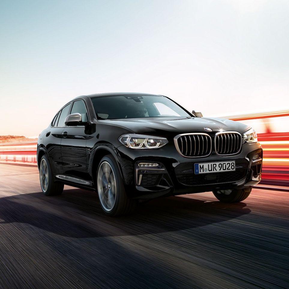 BMW X4 M40i、斜めフロント・ビュー。F98 ブラック・サファイア・メタリックのBMW X4 M40i、エクステリア、斜めフロント・ビュー、ライト・ストリップの見える左側面。F98