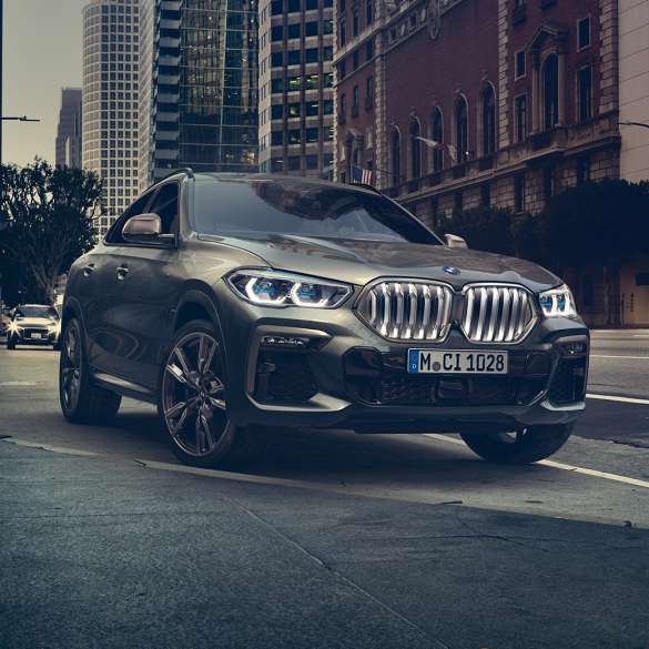 BMW X6 アダプティブ M サスペンション プロフェッショナル BMW X6フロントスリークォータービュー。ある都市風景を背景に。