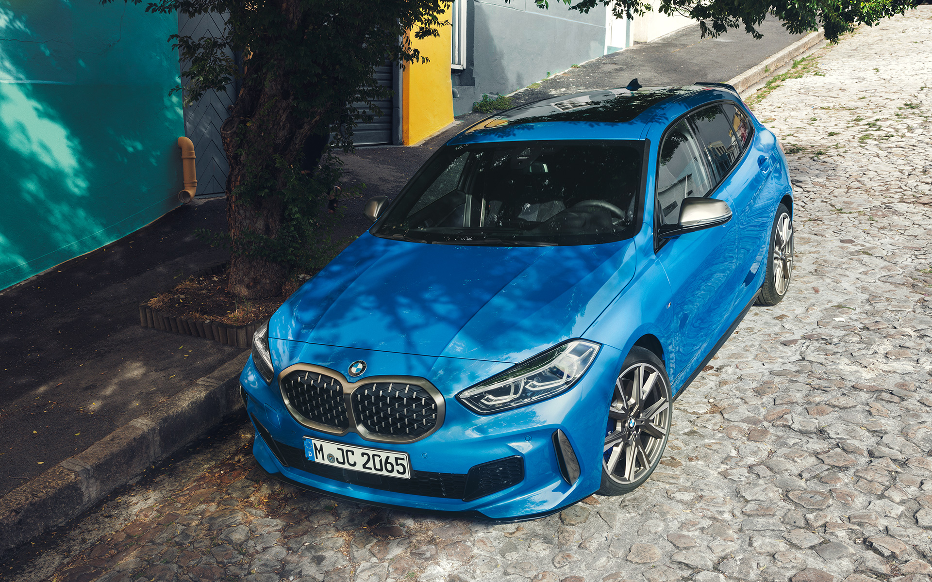 BMW 1シリーズ M135i F40 ミサノ・ブルー・メタリック、上から見た斜めからのフロント・ビュー、沿道に駐車中