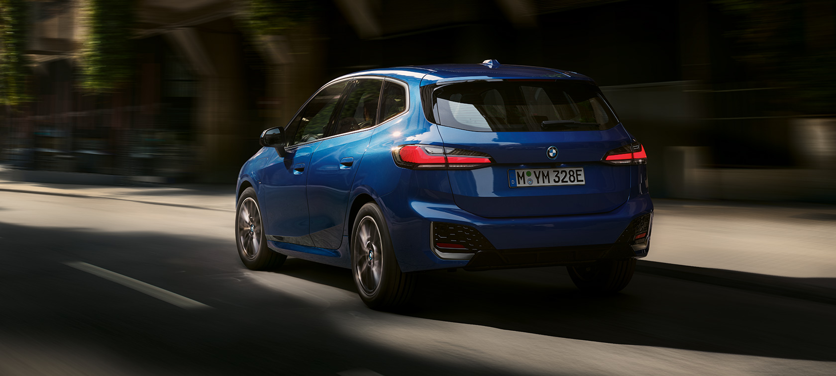 BMW 2シリーズ アクティブ ツアラー230e プラグイン・ハイブリッド U06 2021 M ポルティマオ・ブルー・メタリック、斜めからのリヤ・ビュー、市街地を走行中