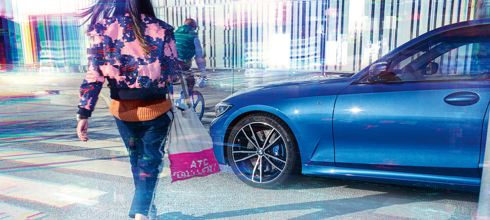 BMW 3 シリーズ セダンのスリークォーター・サイド・ビュー。G20 都市部の路上での乗車シーン。 BMW 3 シリーズ セダンのスリークォーター・サイド・ビュー。 G20