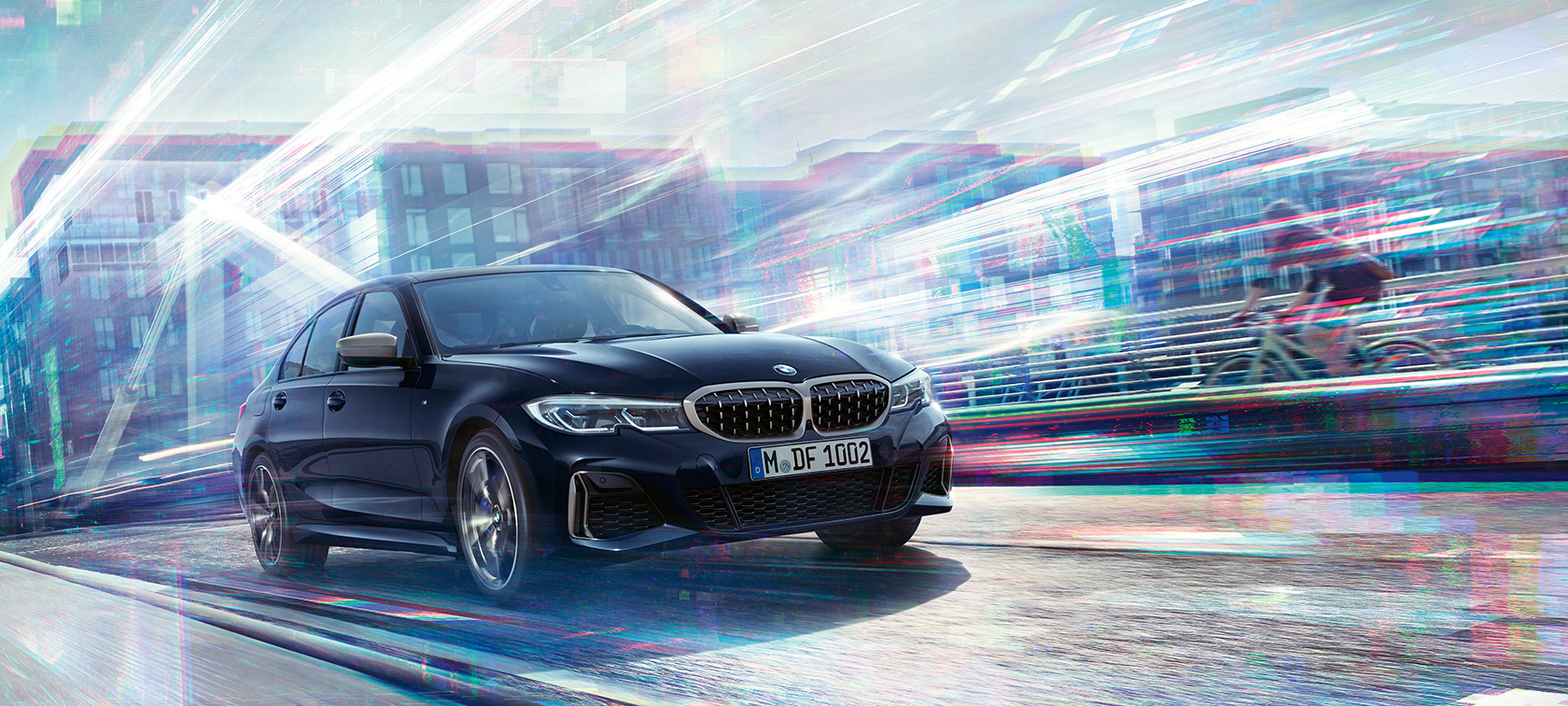 BMW 3シリーズ セダン、BMW M340i xDrive。 都市を背景にして駆けぬけるBMW M340i xDrive、スリークォーター・サイド・ビュー。