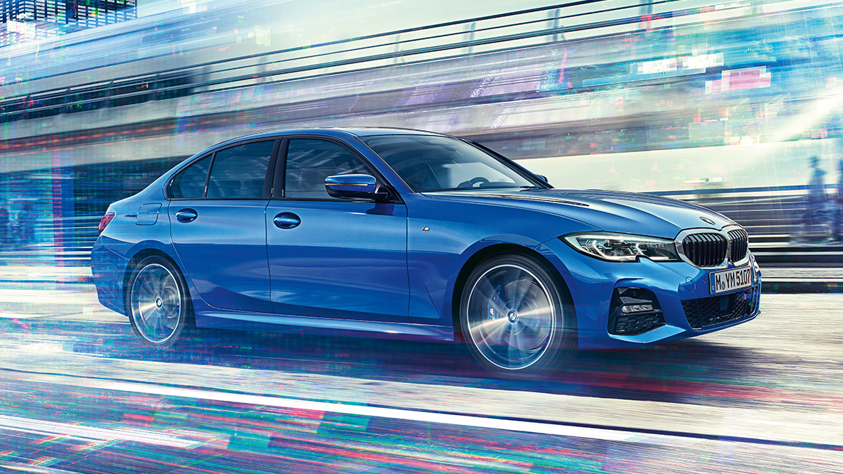 BMW 3シリーズ セダン(G20)、走行中のショット。 日中の都市風景のなかで走行中のBMW 3シリーズ セダン(G20)、横からのショット。