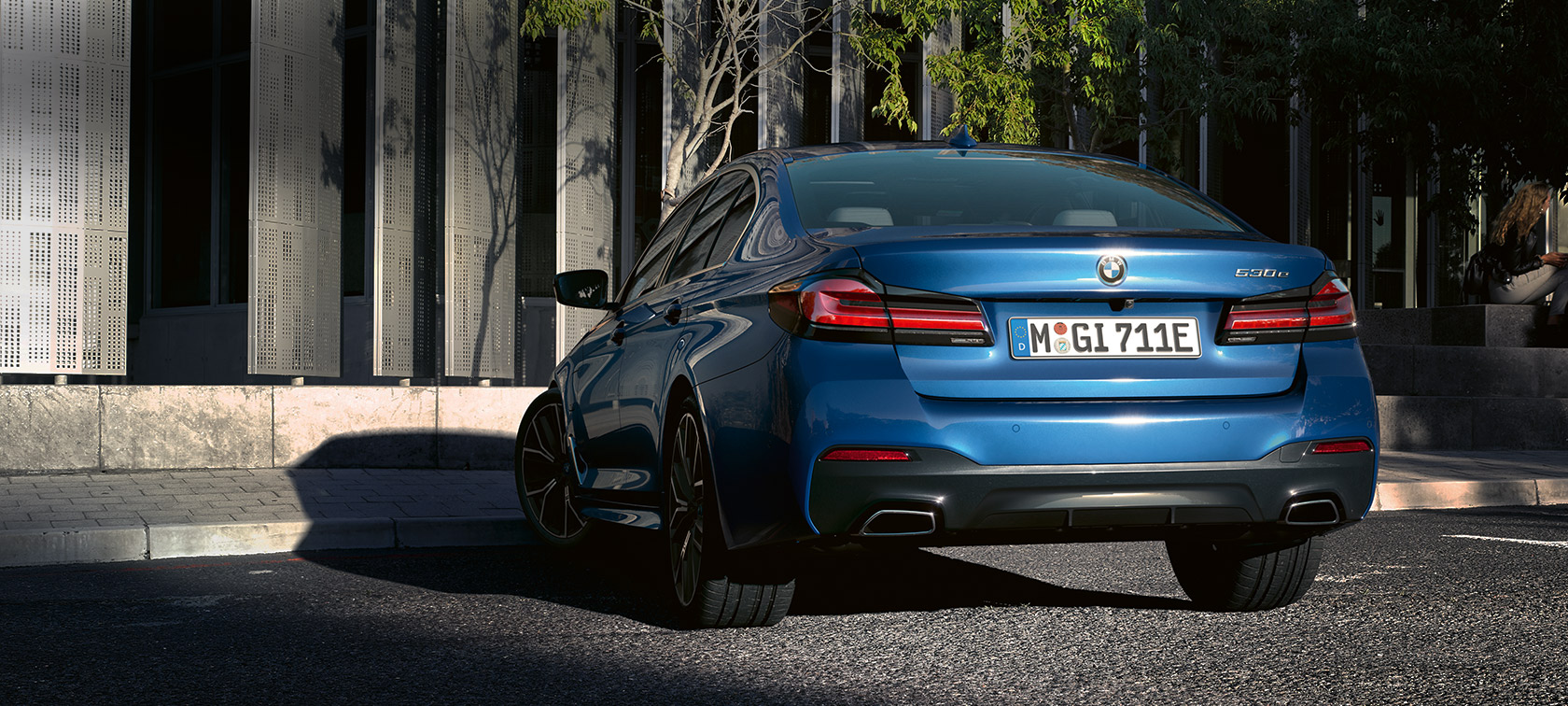 BMW 5 シリーズ セダン(G30) eDrive ファイトニック・ブルー・メタリック BMW 5 シリーズ セダン(G30) eDrive ファイトニック・ブルー・メタリック 建物の前に駐車しているBMWのリヤ・ビュー
