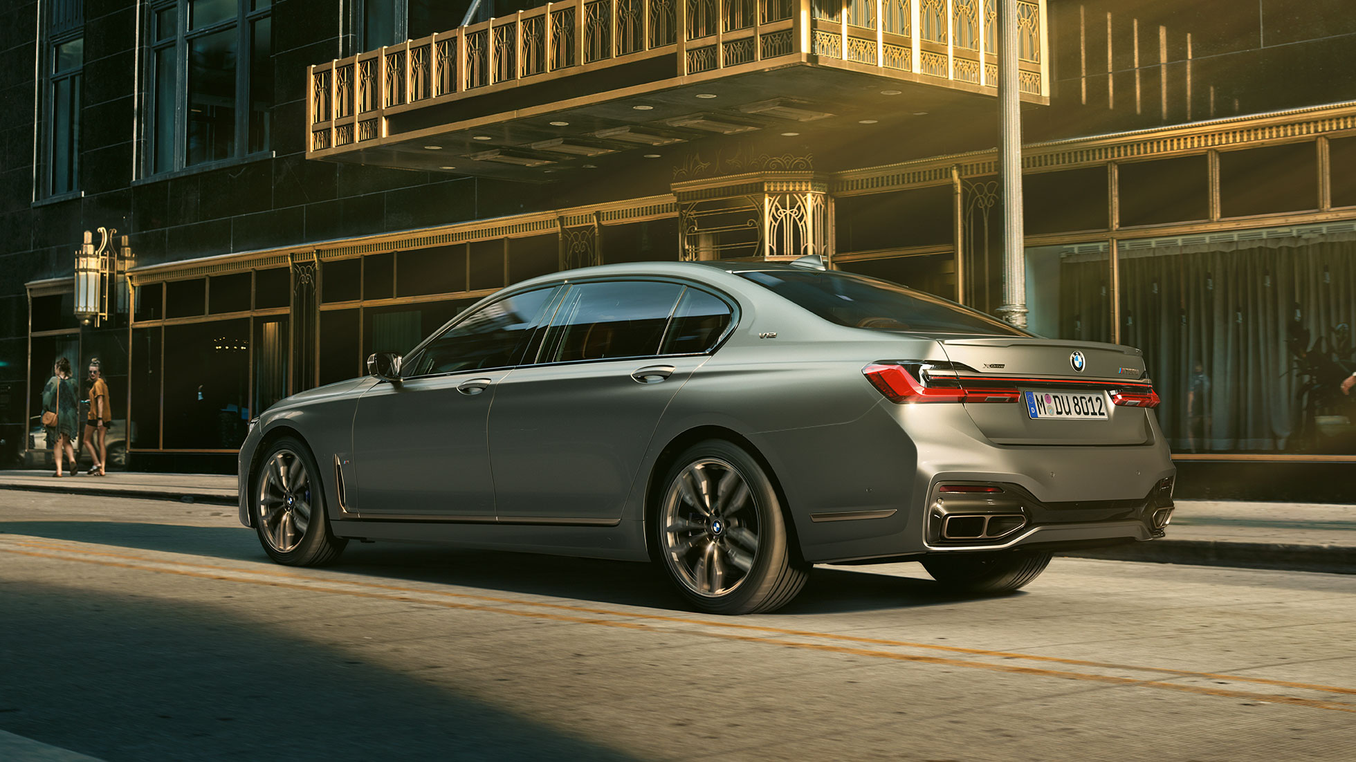 V12 エンジンを搭載したBMW M760Li xDrive 都市部の高層ビルを背景に佇むBMW M760Li xDriveの側面リヤからのビュー