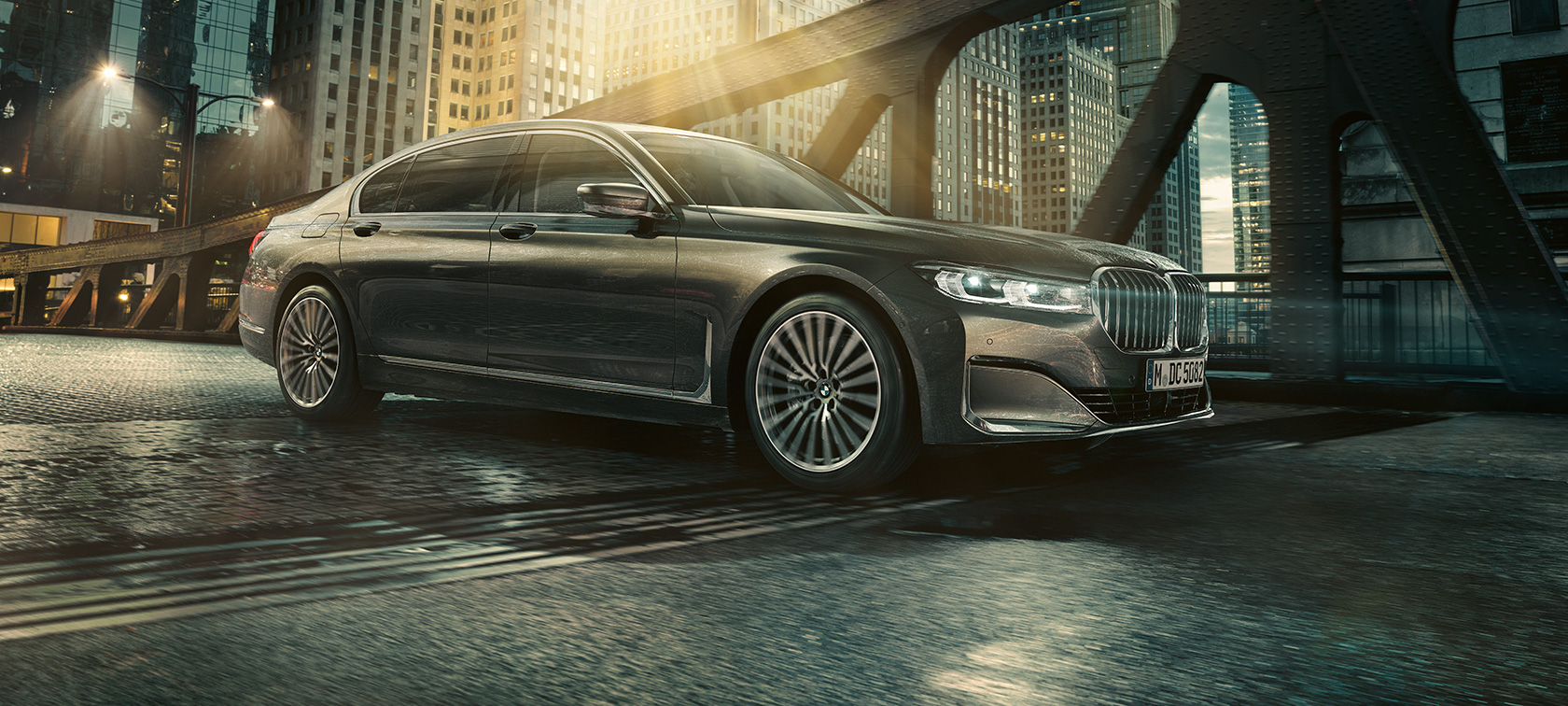 BMW 7シリーズ セダン サイド・ビュー 照明の当たったホテルの前に停車しドアを開いたBMW 7シリーズ セダンのサイド・ビュー