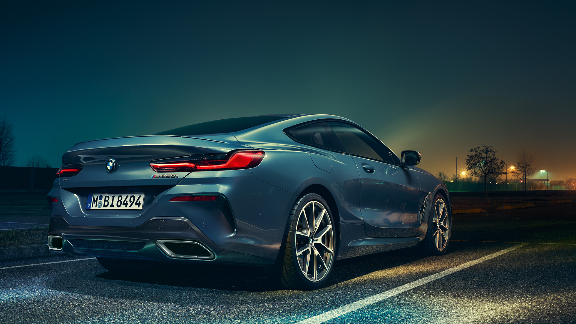 BMW 8シリーズ クーペ、斜めからのリヤ・ビュー。 BMW 8シリーズ クーペ、斜めからのリヤ・ビュー、夜景を背景に。