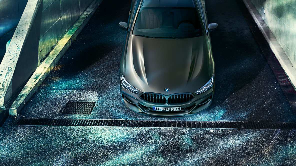 佇むBMW 8シリーズ クーペのフロント・ショット。 夜の都会に佇むBMW Individualの装備が施されたBMW 8シリーズ クーペのフロント・ショット。