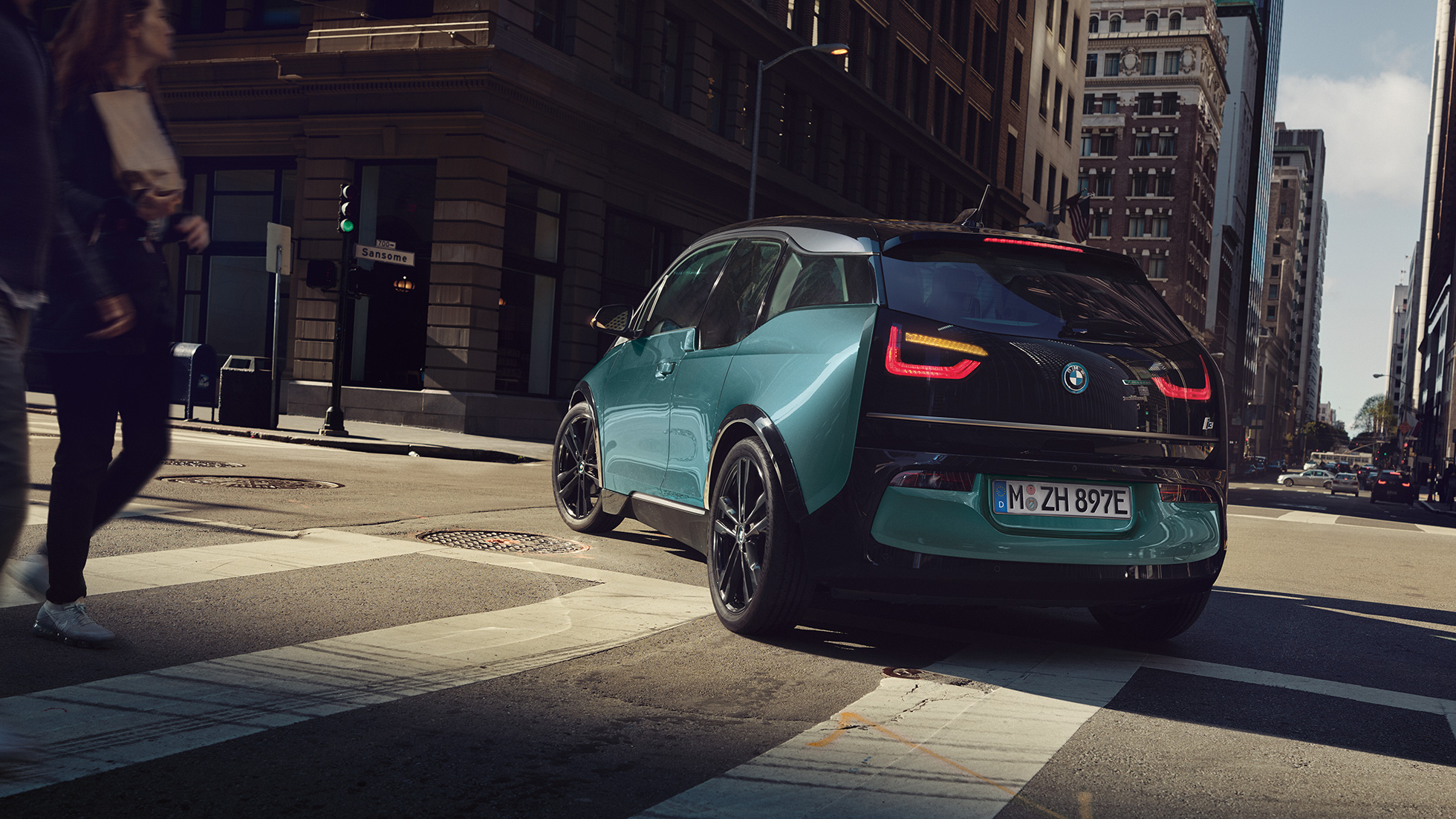 BMW i3 2018 斜めからのリヤ・ビュー 走行中 BMW i3 I01 2018 フカロ・ベージュ フローズン・グレー・メタリック・ハイライト付 斜めからのリヤ・ビュー 都会を走行中
