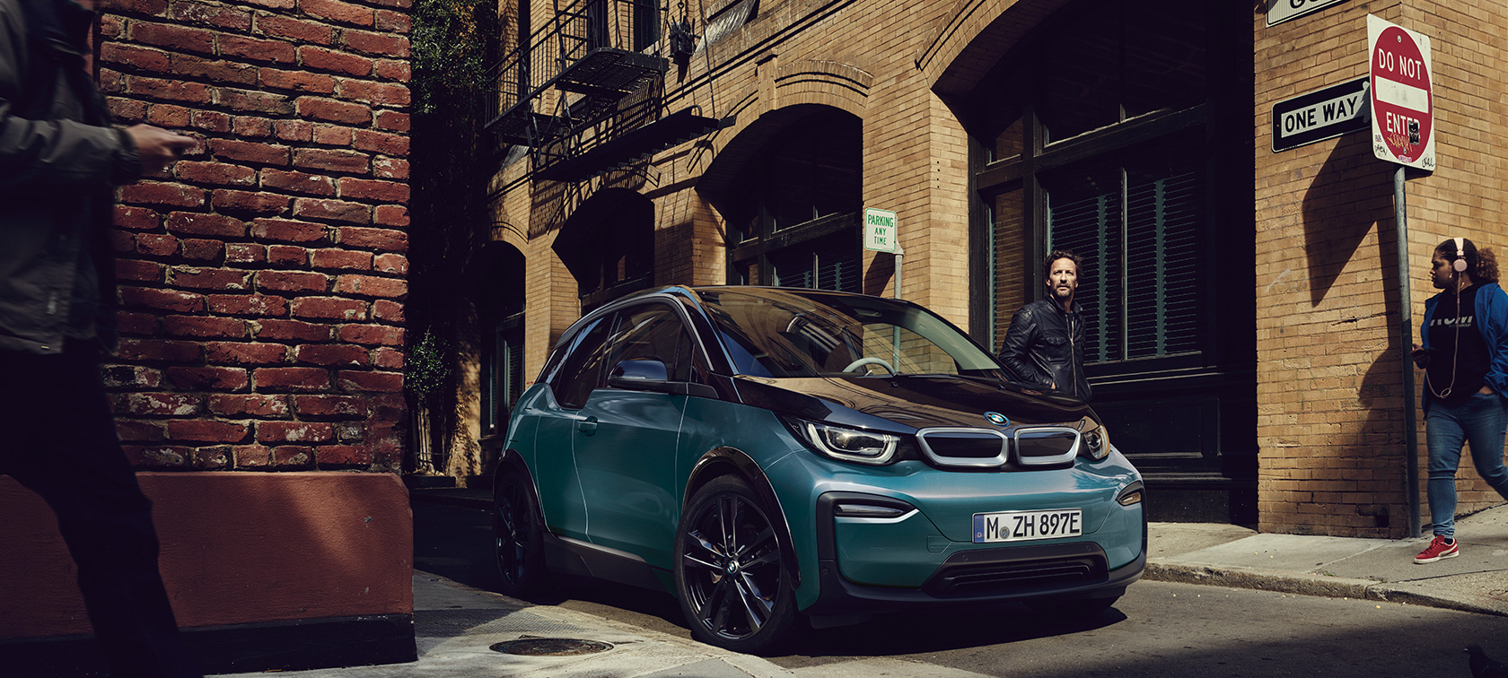 BMW i3 I01 2018　フカロ・ベージュ フローズン・グレー・メタリック・ハイライト付 斜めからのフロント・ビュー 都会に駐車中