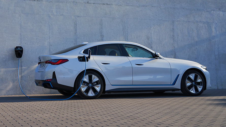 サイド・ビュー BMW Wallbox BMW i4 eDrive40 G26 電気自動車 2021 斜めからのフロント・ビュー BMW i4 eDrive40 G26 電気自動車 2021 ミネラル・ホワイト、BMW充電ステーションと共に