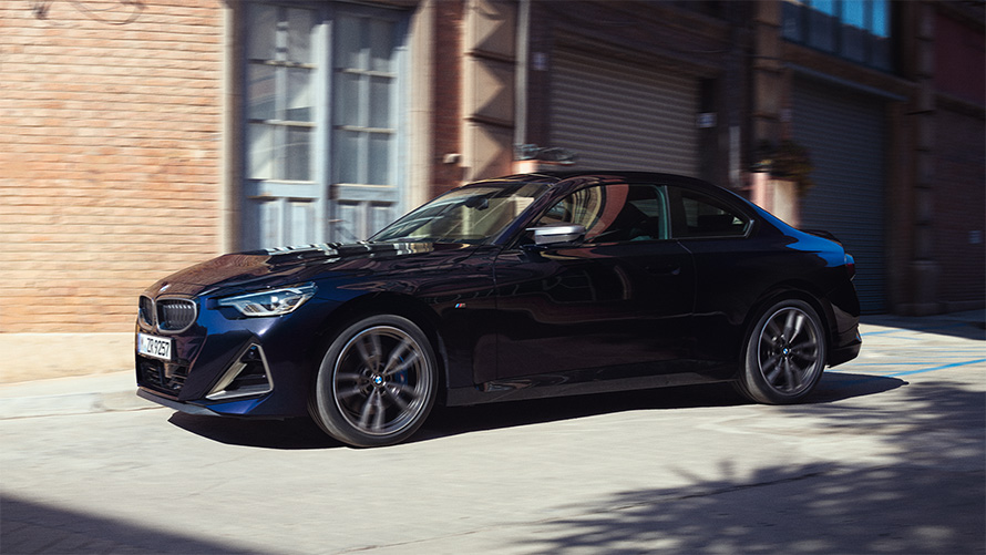 BMW M240i xDriveクーペ G42 2021 ブラック・サファイア・メタリック 斜めからのサイド・ビュー 倉庫前に停車中