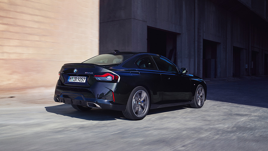 BMW M240i xDriveクーペ G42 2021 ブラック・サファイア・メタリック 斜めからのリヤ・ビュー 倉庫前に停車中