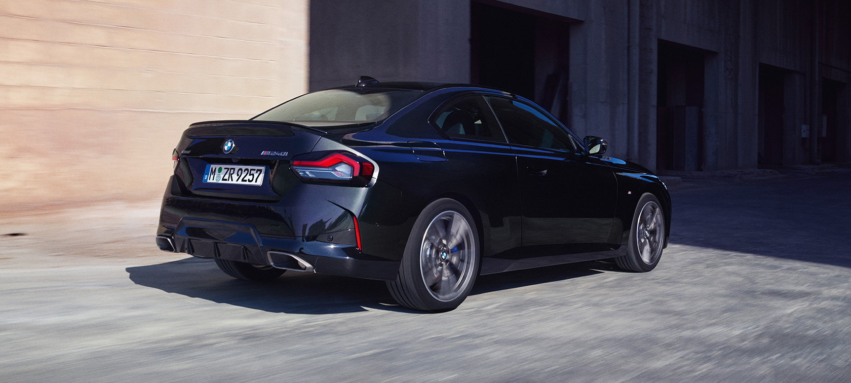 斜めからのリヤ・ビュー BMW M240i xDriveクーペ G42 2021 BMW M240i xDriveクーペ G42 2021 ブラック・サファイア・メタリック 斜めからのリヤ・ビュー 走行中