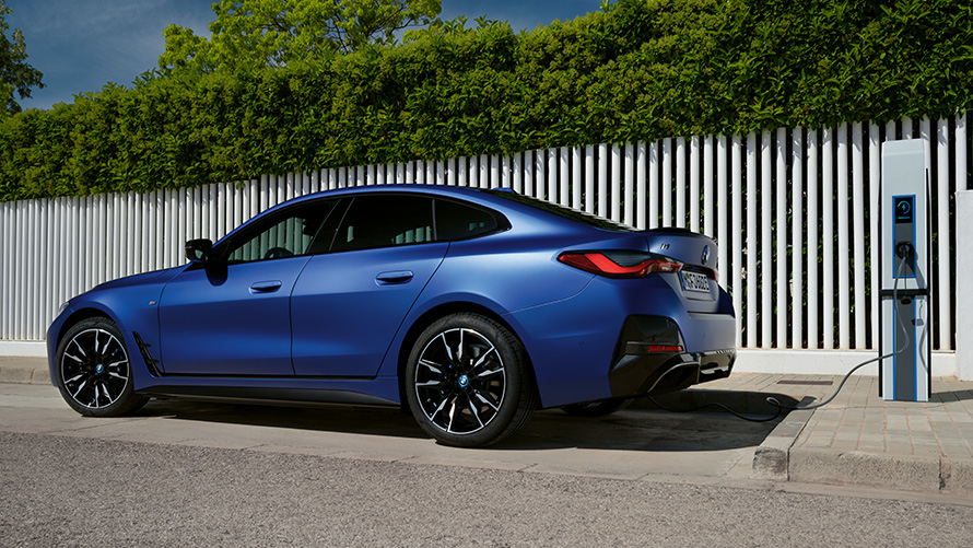 サイド・ビュー BMW i4 M50 G26 電気自動車 2021 公共高速充電ステーションにて BMW i4 M50 G26 電気自動車 2021 BMW Individual フローズン・ポルティマオ・ブルー・メタリック 公共高速充電ステーションでのサイド・ビュー