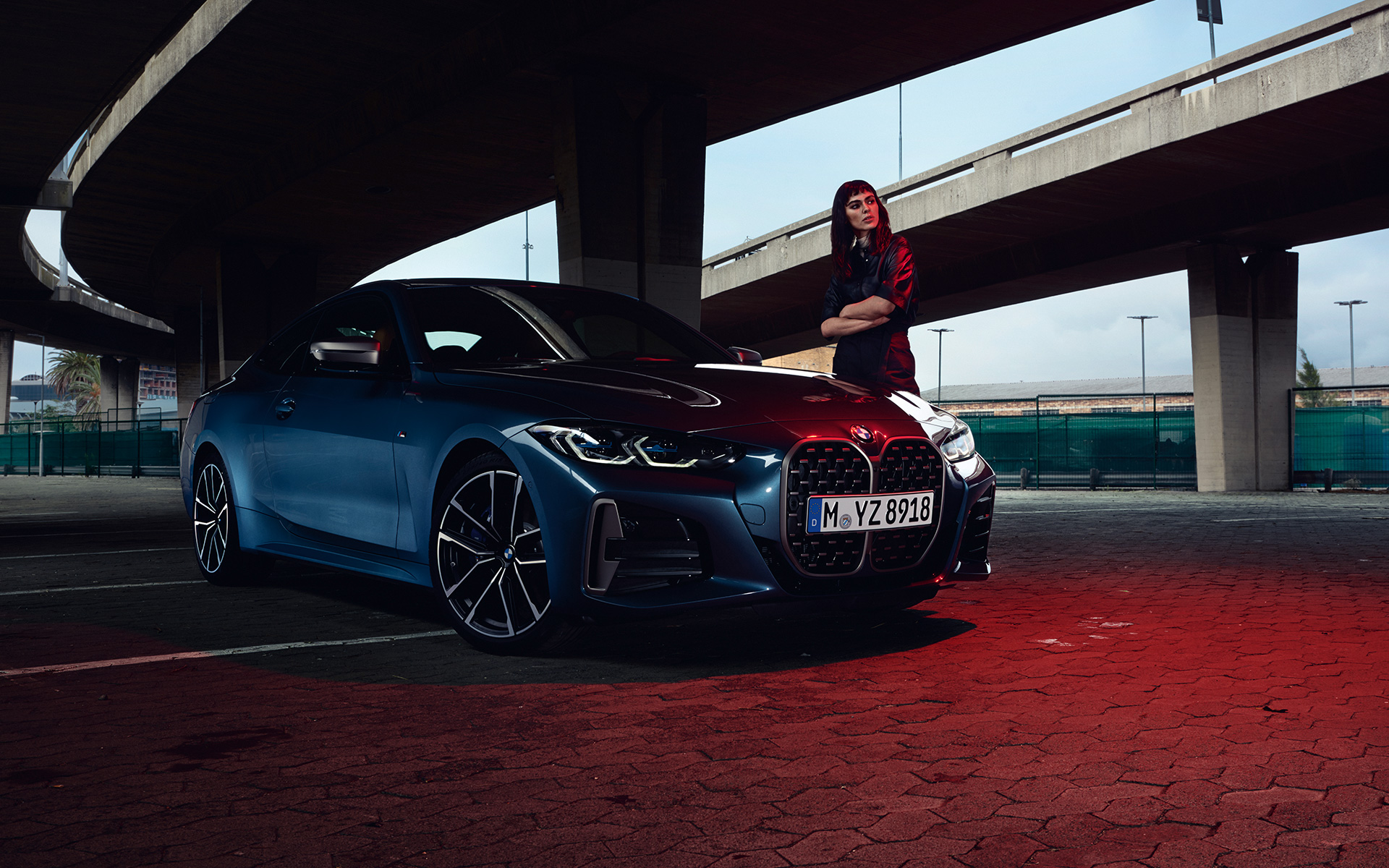 BMW M440i xDrive G22 アークティック・レース・ブルー、斜めからのフロント・ビュー、モデルと共に