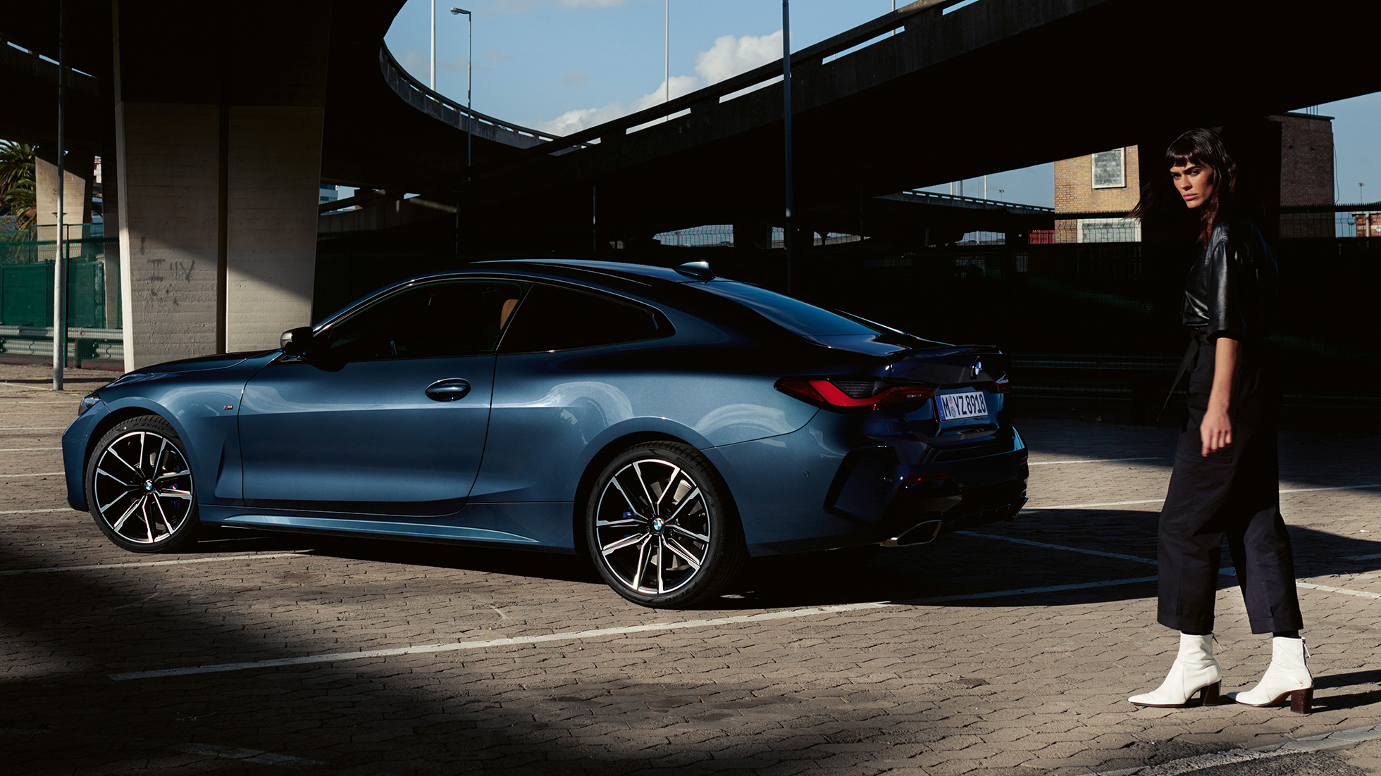 BMW M440i xDrive クーペ G22 2020 - 斜めからのリヤ・ビュー、モデルと共に BMW M440i xDrive クーペ、アークティック・レース・ブルー・メタリック G22 2020 - 斜めからのリヤ・ビュー、モデルと共に