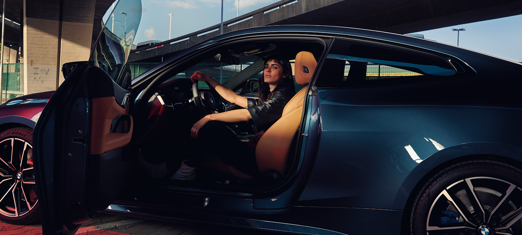 モデルがいるサイド・ビュー、BMW M440i xDrive クーペ G22 2020 BMW M440i xDrive クーペ G22 2020 アークティック・レース・ブルー・メタリック - ドアを開いた車内にモデルがいるサイド・ビュー