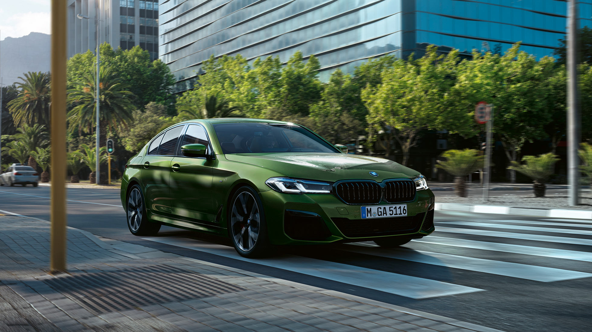 BMW M550i xDriveセダン G30 LCI フェイスリフト 2020 走行中の斜めからのフロント・ビュー BMW M550i xDriveセダン G30 LCI フェイスリフト 2020 BMW Individual ベルデ・エルメス・メタリック 市街地走行中の斜めからのフロント・ビュー