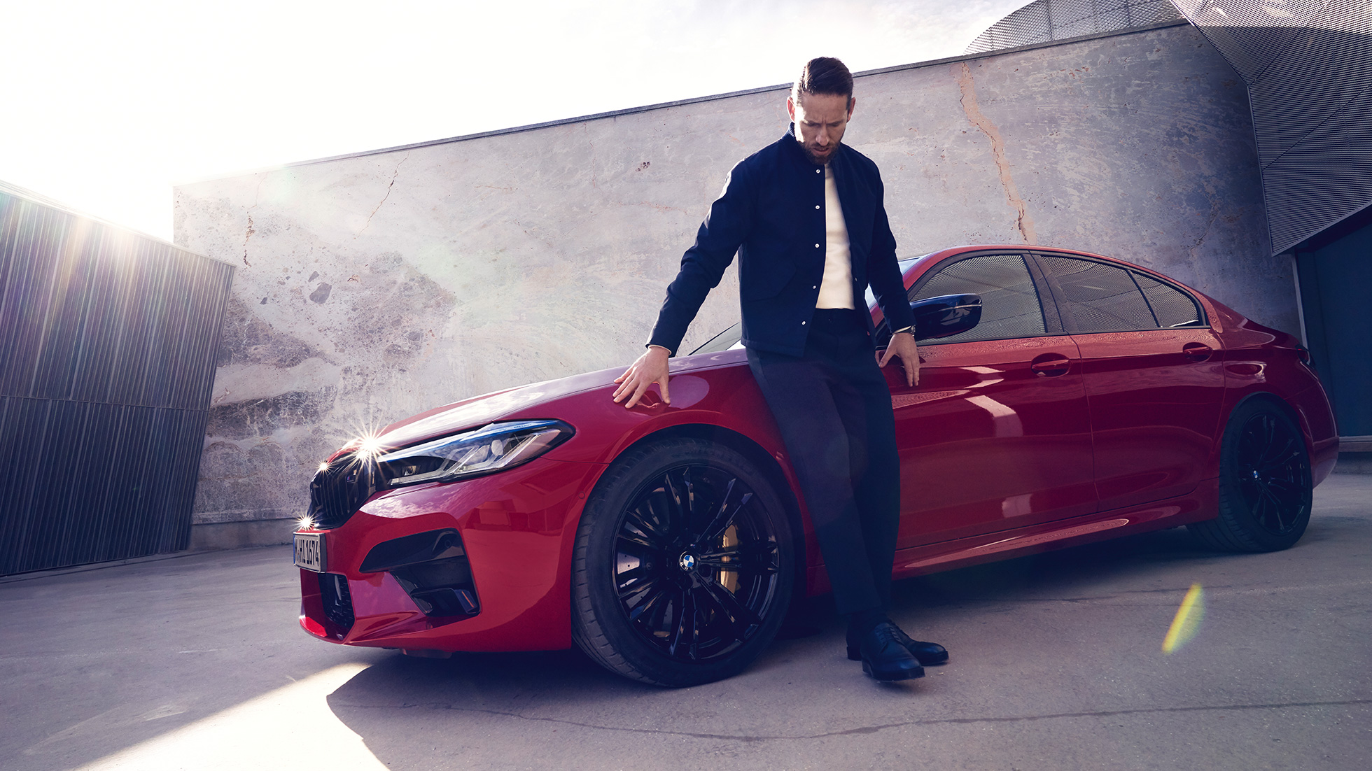 BMW M5 Competition F90 LCI フェイスリフト 2020 サイド・ビューと男性 BMW M5 Competition F90 LCI フェイスリフト 2020 BMW Individual イモラ・レッド サイド・ビューと男性