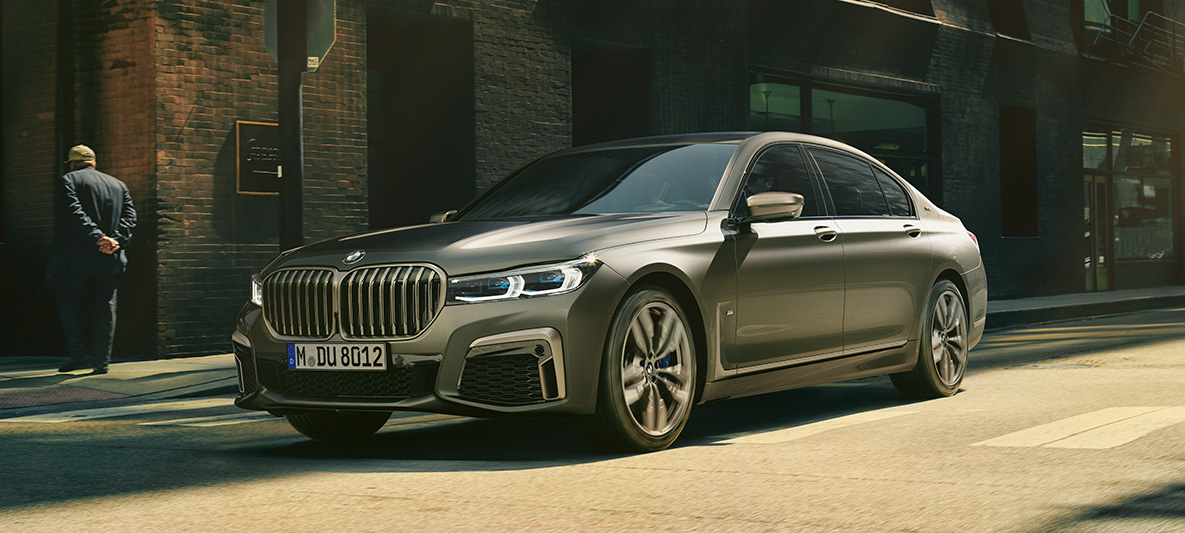 BMW M760Li xDrive セダン G11 G12 2019 フローズン・ダーク・シルバー・メタリック 斜めからのリヤ・ビュー 都市風景のなかで走行中 BMW M760Li xDrive セダン G11 G12 2019 フローズン・ダーク・シルバー・メタリック 斜めからのリヤ・ビュー 都市風景のなかで走行中