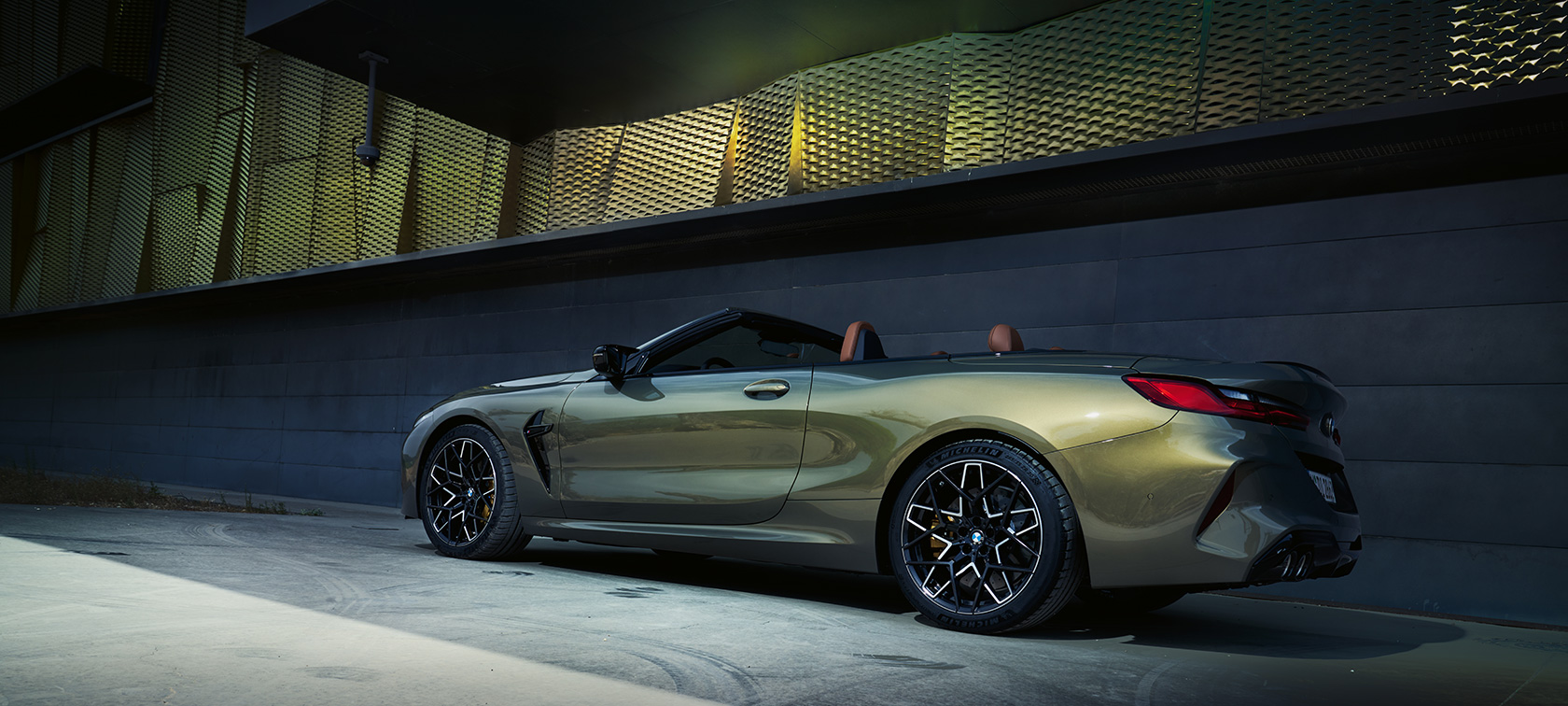 BMW M8 Competition カブリオレ F91 LCI フェイスリフト 2022 BMW Individualブラス・メタリック 斜めからのサイド・ビュー 壁の前に停車中