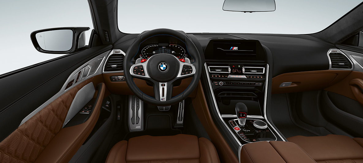 BMW M8 クーペ、コックピット。 BMW M8 クーペ、Mレザーステアリングホイールを装着したコックピット。ステアリングホイールには赤いM1/M2ボタン。