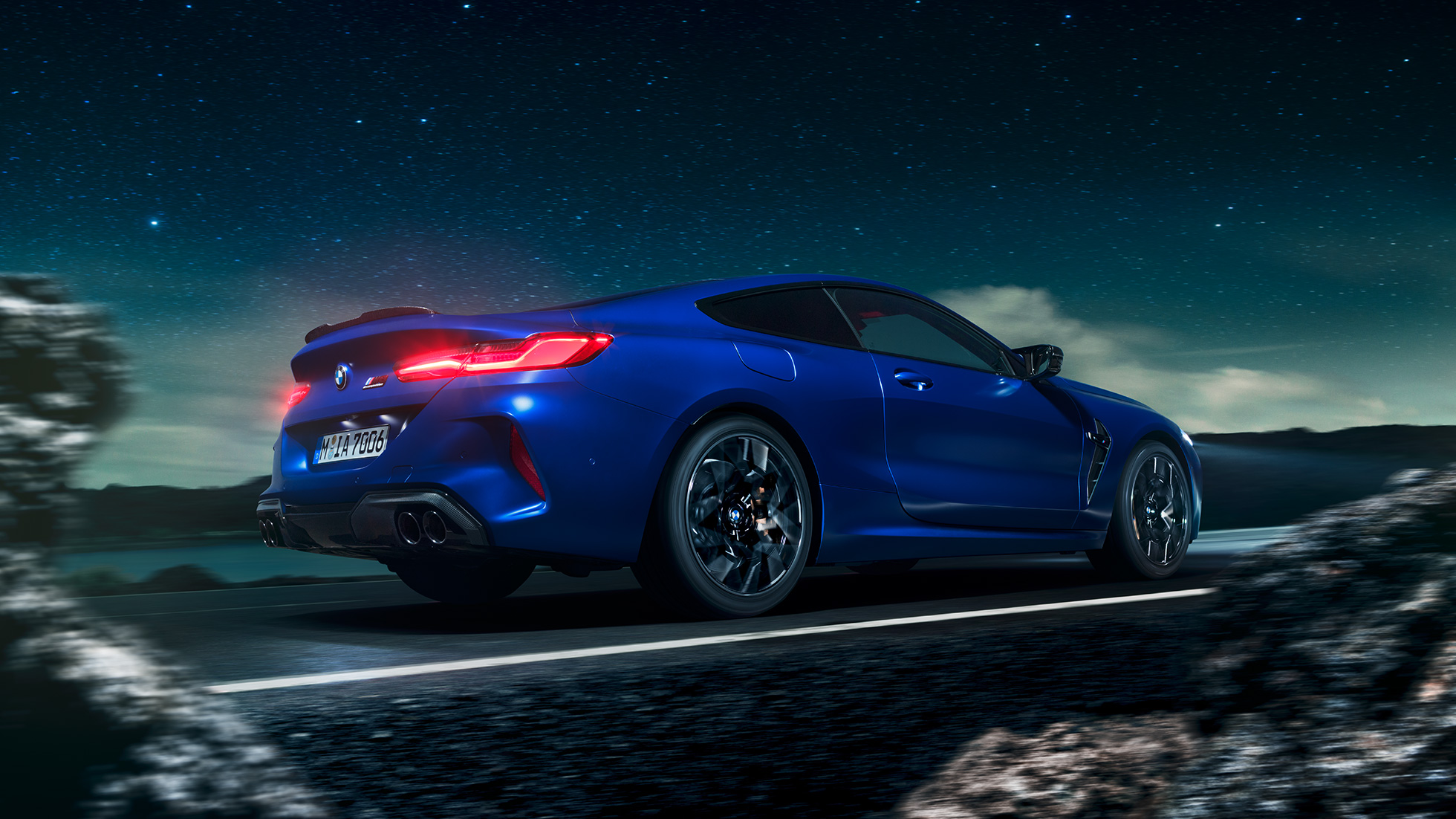 BMW M8 コンペティションクーペ、スリークォーターサイドビュー。F92 BMW M8 コンペティションクーペ(塗色マリーナベイ ブルーメタリック)。満天の星を背景に疾走するスリークォーターサイドビュー。F92