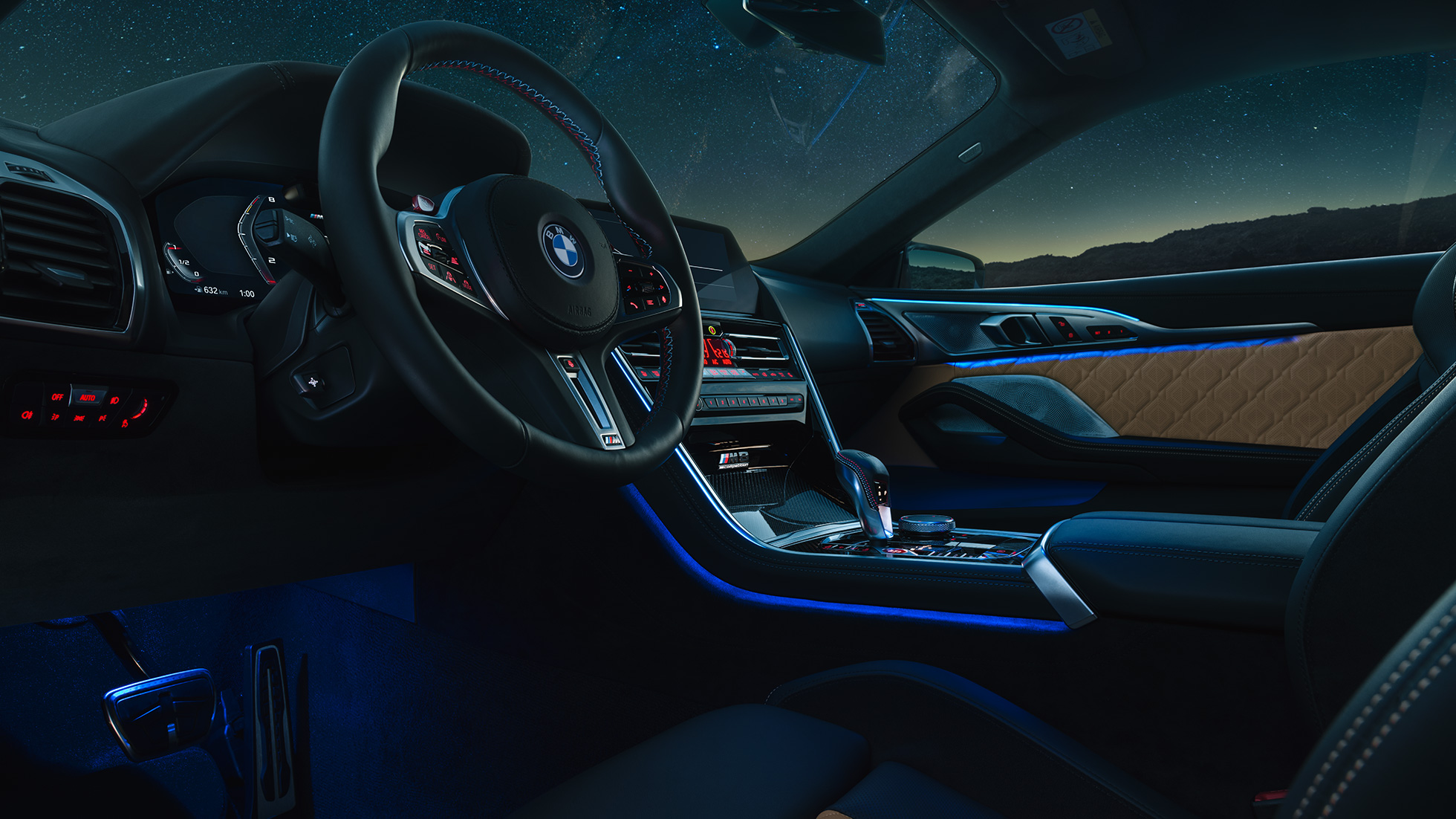 BMW M8 コンペティションクーペ、コックピット。F92 BMW M8 コンペティションクーペ、Mレザーステアリングホイールとブルーの間接照明が美しい夜のコックピット。F92
