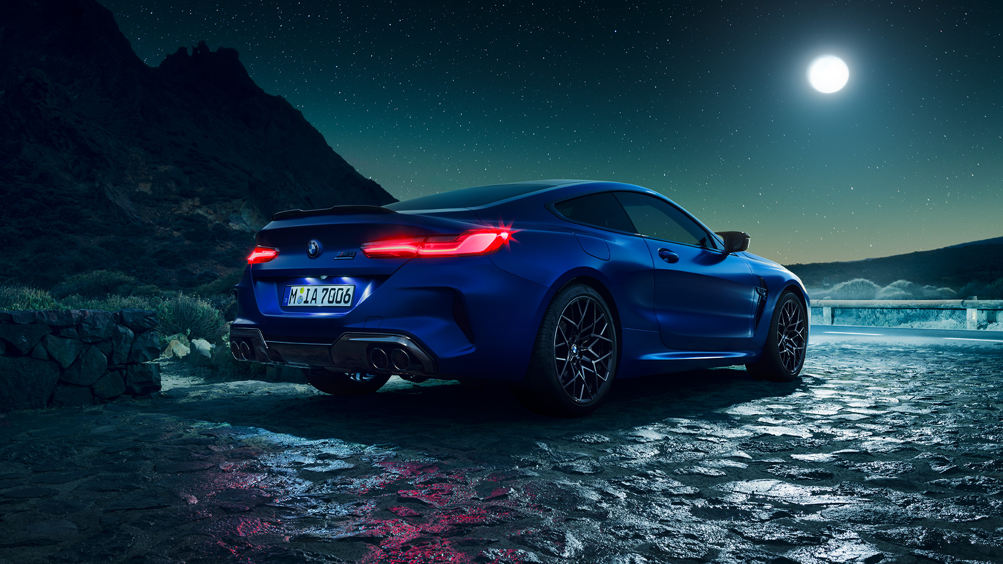 BMW M8 コンペティションクーペ、スリークォーターリアビュー。F92 BMW M8 コンペティションクーペ(塗色マリーナベイ ブルーメタリック)。満月を背景にきらめくLEDテールランプが印象的なスリークォーターリアビュー。F92