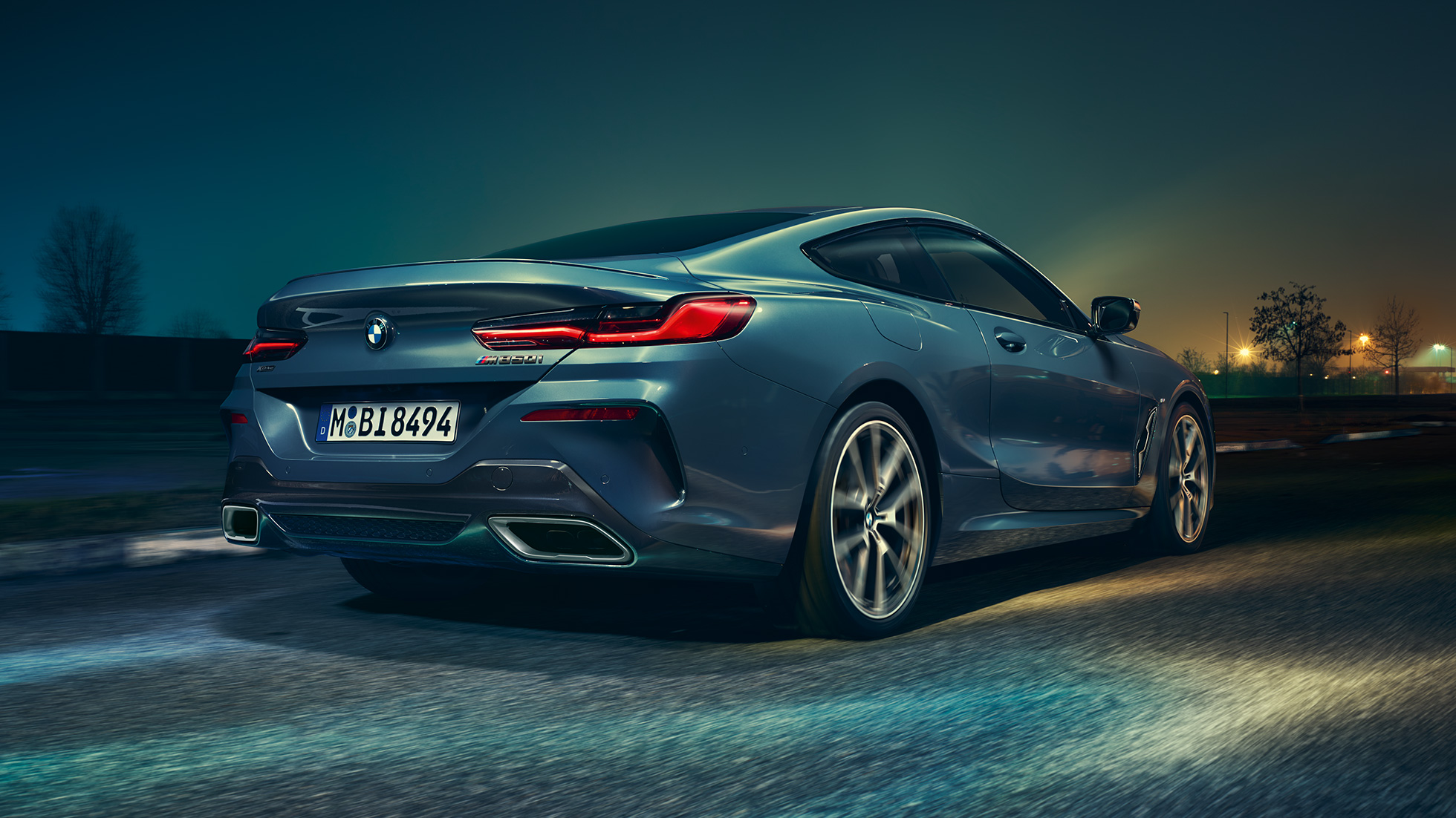 BMW M850i xDriveクーペ、リアビュー。G15 BMW M850i xDriveクーペ(塗色バルセロナ ブルーメタリック)。夜間に疾走するリアビュー。G15