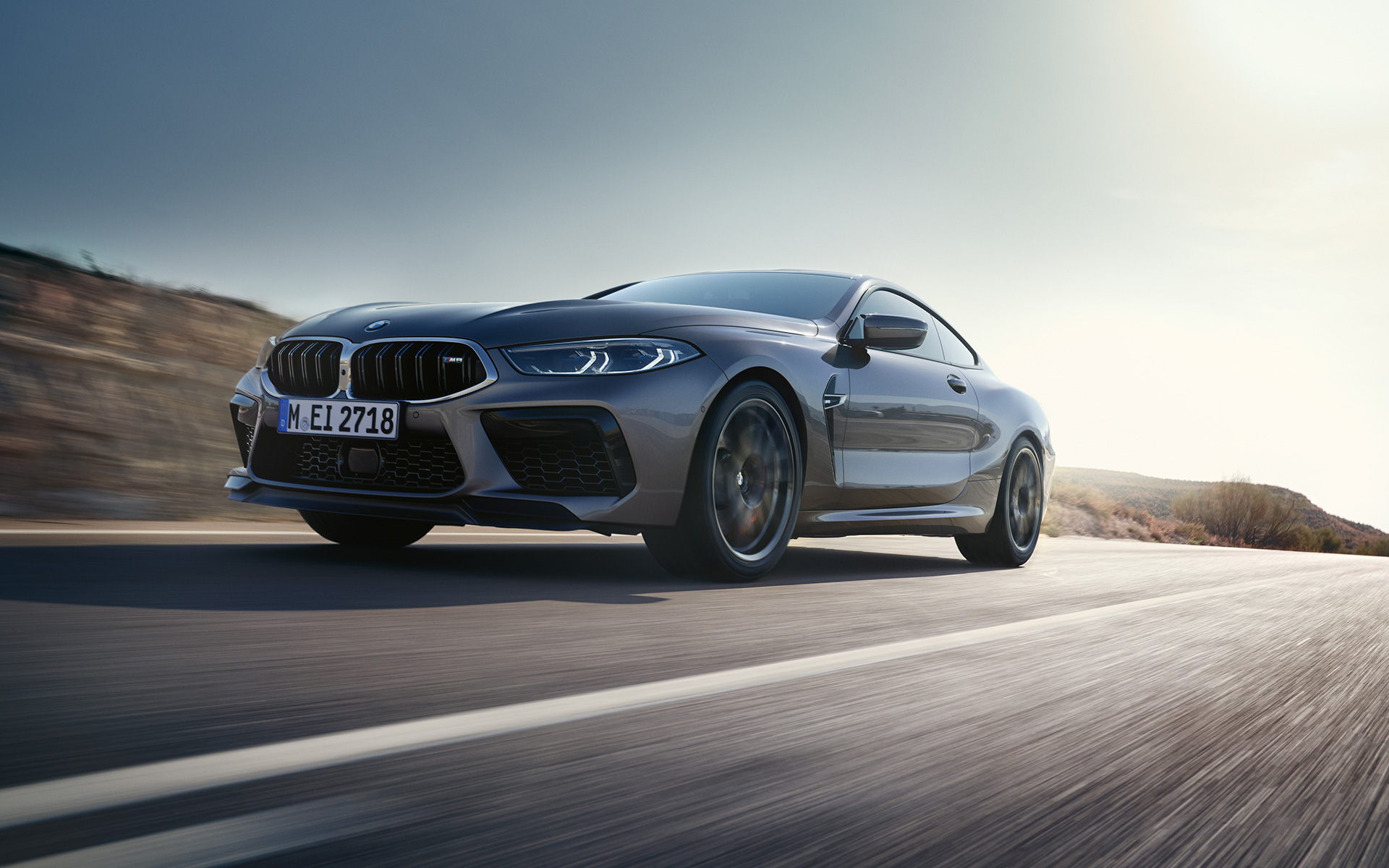 BMW M8 クーペ F92 LCI フェイスリフト 2022 スカイスクレイパー・グレー・メタリック 斜めからのフロント・ビュー 高速道路を走行中 ロー・アングル・ショット