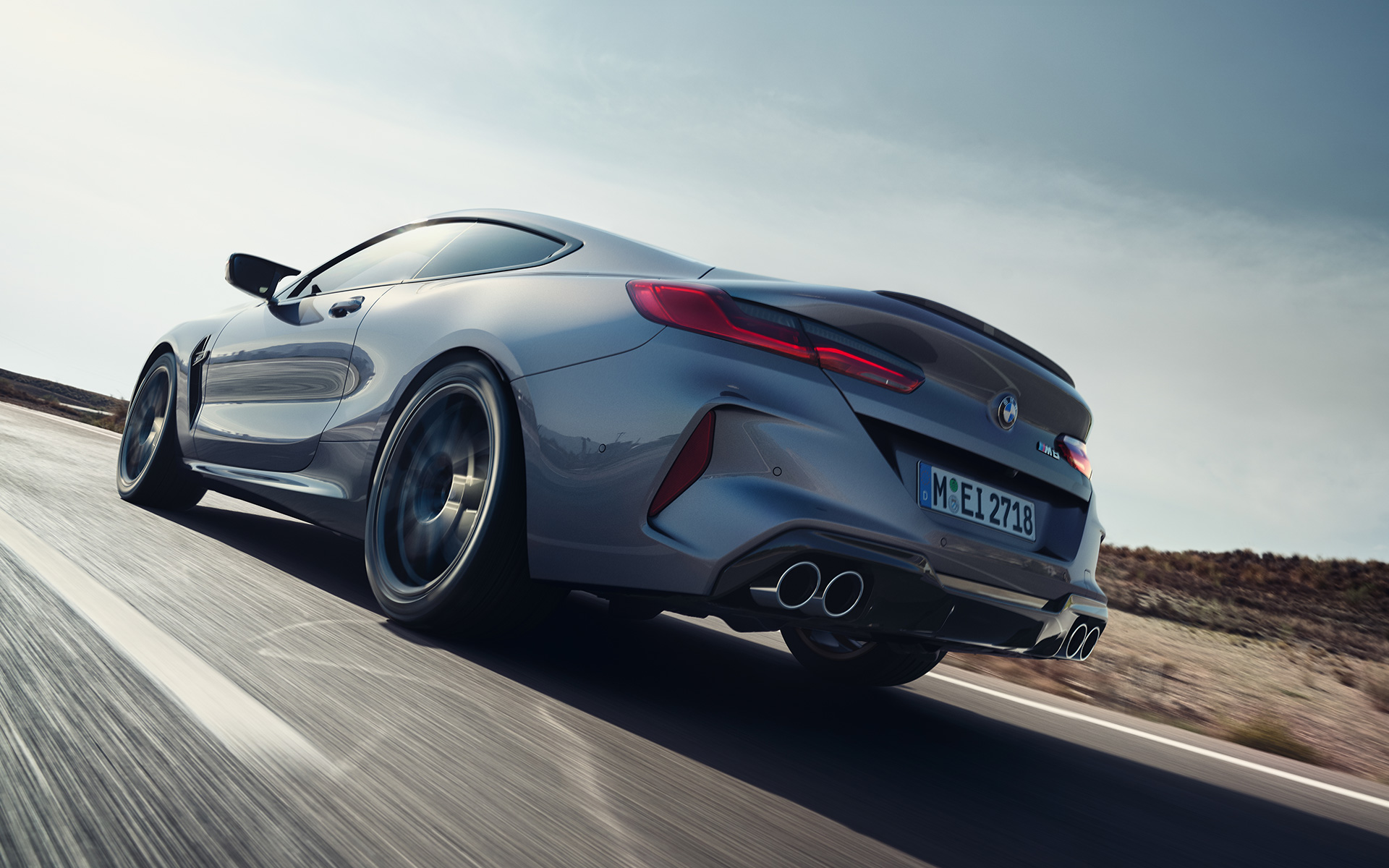 BMW M8 クーペ F92 LCI フェイスリフト 2022 スカイスクレイパー・グレー・メタリック 斜めからのリヤ・ビュー 高速道路を走行中 ロー・アングル・ショット
