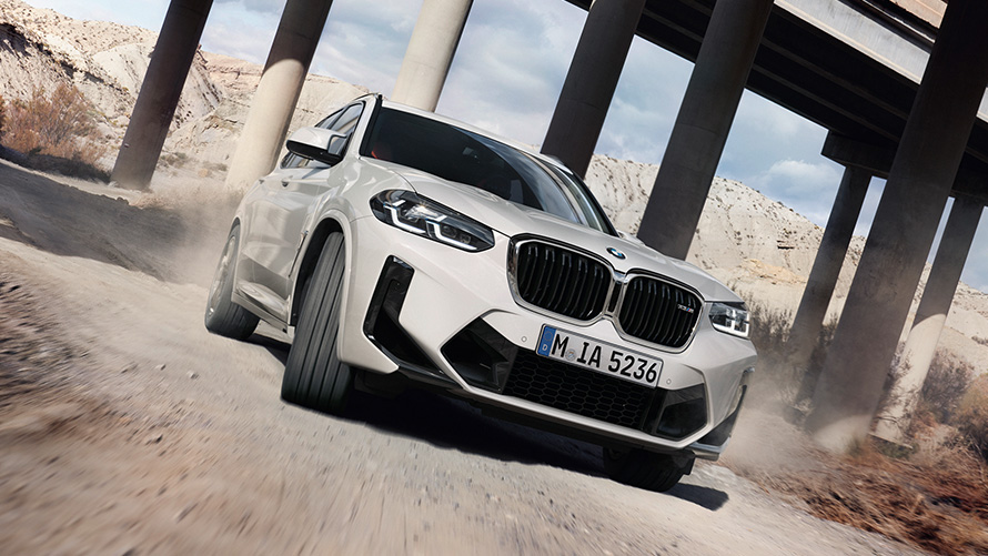 BMW X3 M F97 LCI フェイスリフト 2021 アルペン・ホワイト 斜めからのフロント・ビュー カーブを走行中