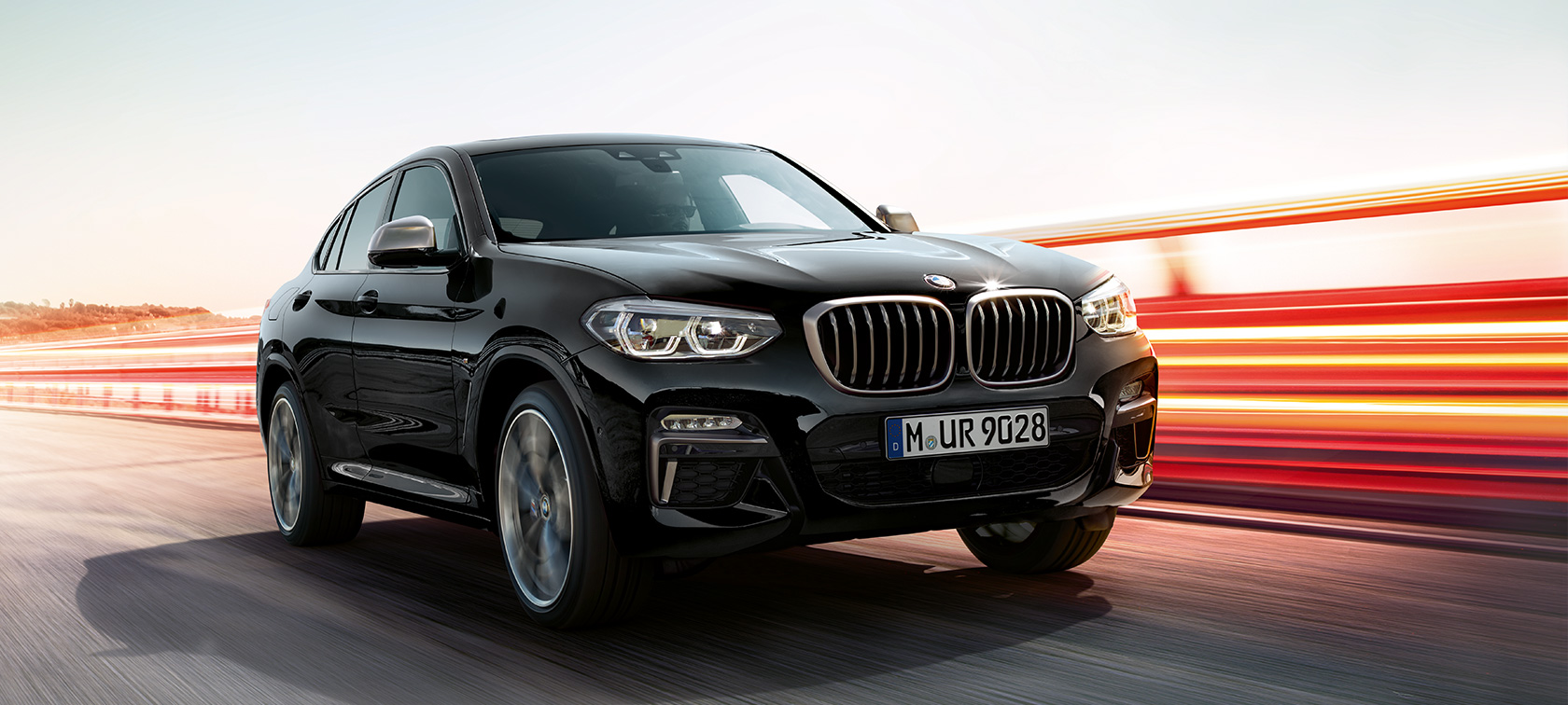BMW X4 M40i、斜め前からのフロント・ビュー、左側面。F98 ブラック・サファイア・メタリックのBMW X4 M40i、エクステリア、斜め前からのフロント・ビュー、左側面、ライト・ストリップ入り。F98