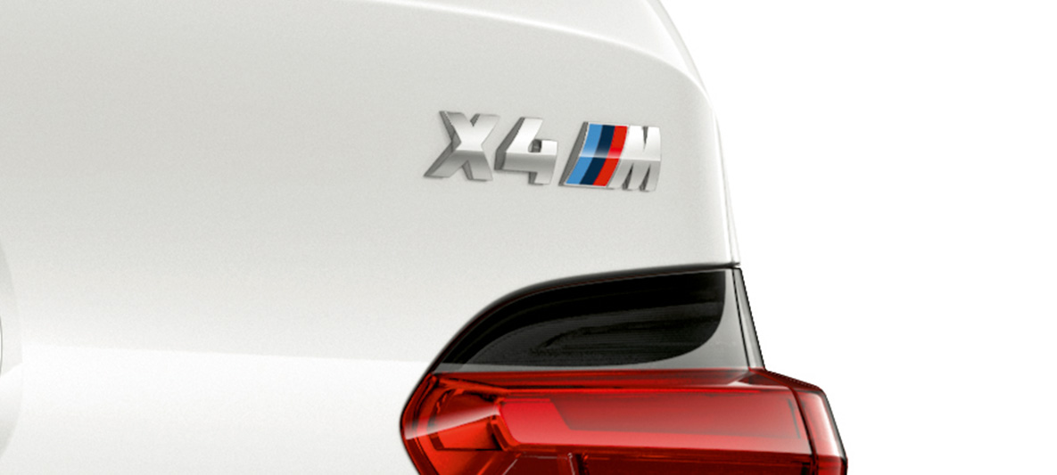 BMW X4 M、モデルロゴ。F98 アルピンホワイトのBMW X4 M、エクステリア、モデルロゴの入ったリヤのクローズアップ画像。F98